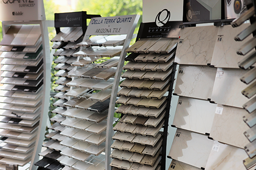 Displays of various quartz and tile samples on angled racks in a showroom.