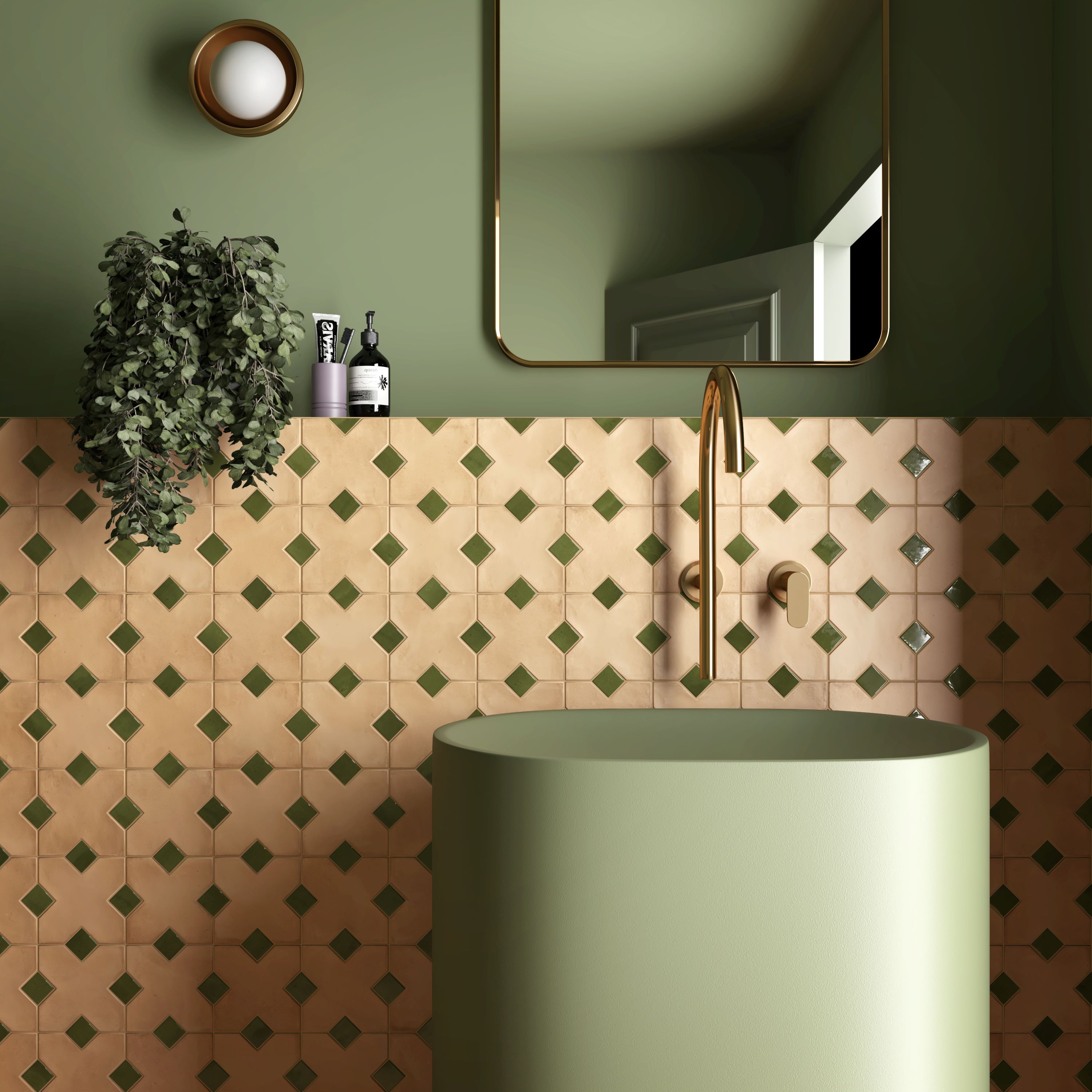 Modern bathroom sink with green cylindrical basin, gold faucet, patterned tiles, and leafy plant on wall.